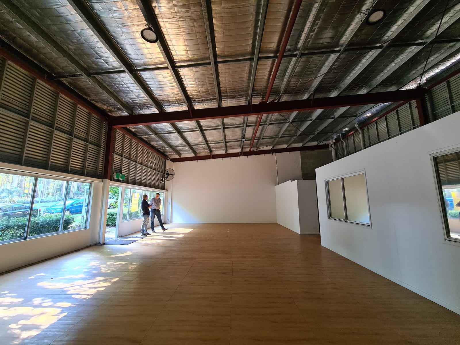Two people inspecting an empty commercial space as a potential future climbing gym location.